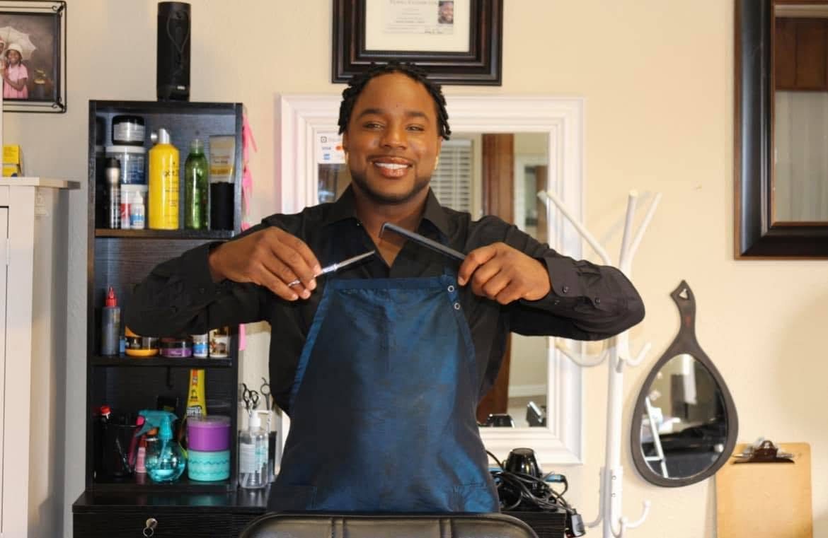 Michael Farris standing at his station in his suite, holding shears