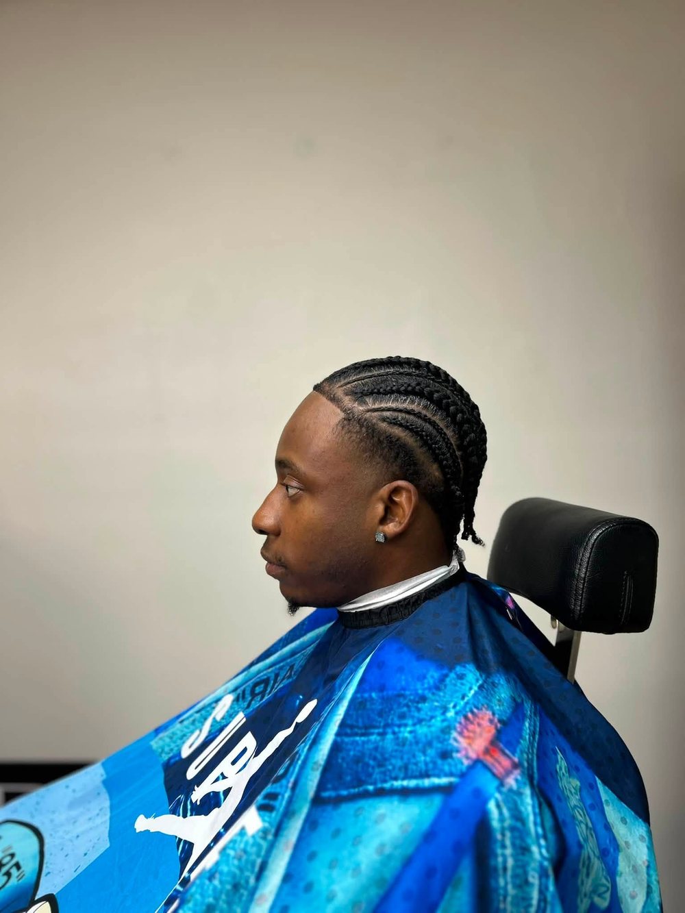 A man with neat cornrows in the styling chair